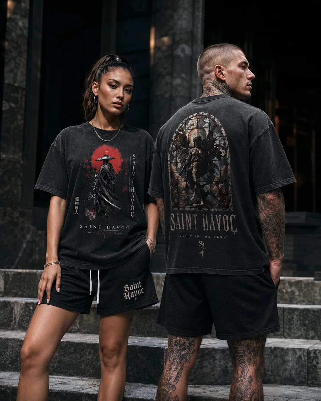 Two models wearing oversized washed-black Saint Havoc graphic tees